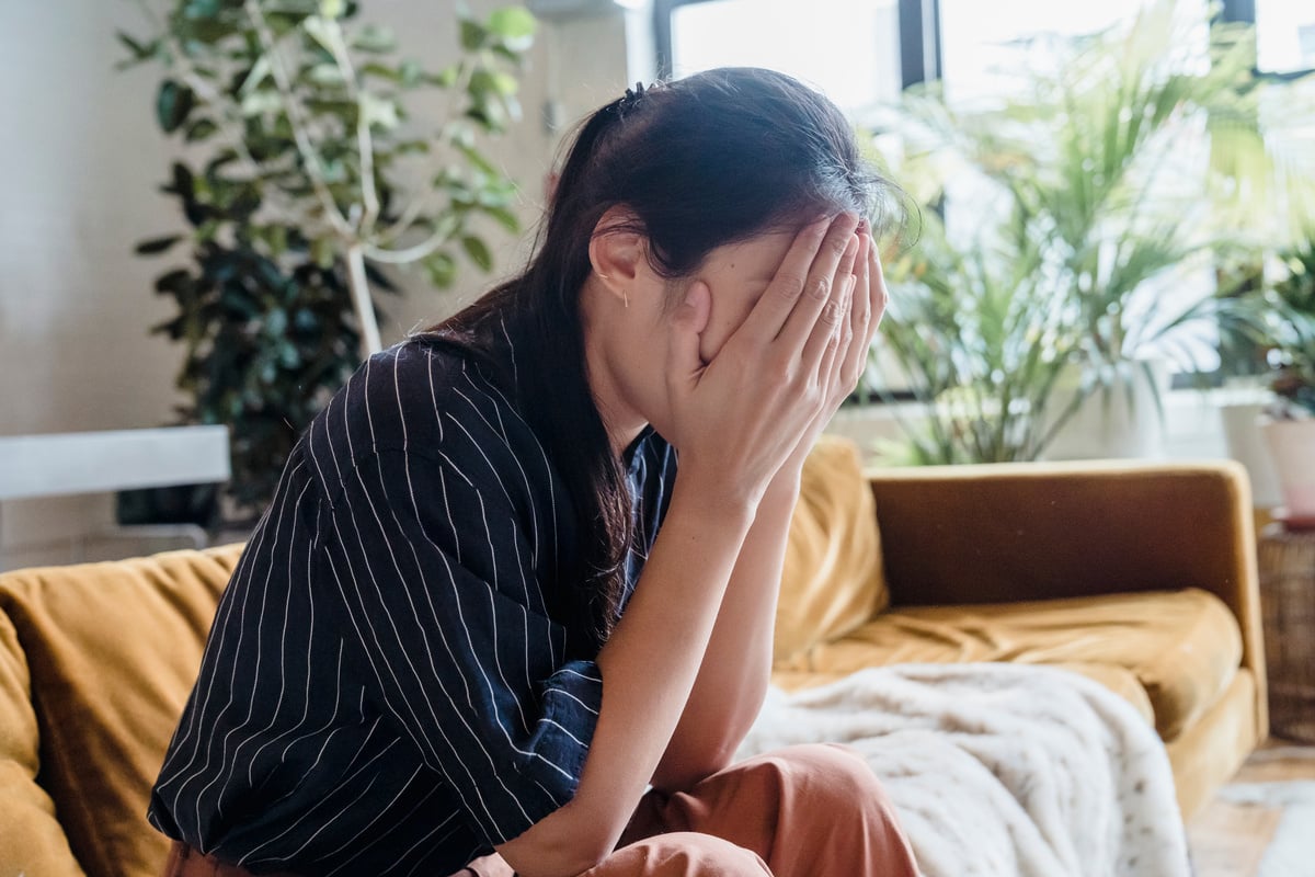 A Problematic Woman Sitting on a Couch while Covering Her Face Using Her Hands